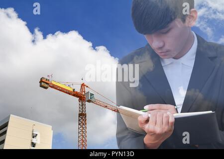 businessman  with notepad in hand signing documents   in construction  site workplace, double exposure concept. Stock Photo