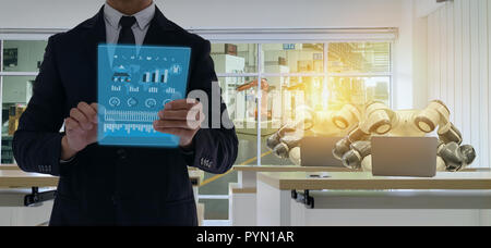 iot smart factory in industry 4.0 robot technology concept, engineer , business man using futuristic tablet to control ,monitor, management robotic to Stock Photo