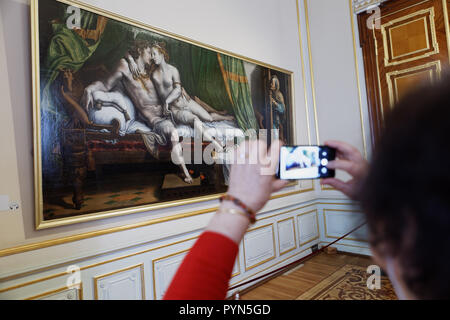 St. Petersburg, Russia - April 05, 2018: Chinese tourist make photo of the painting Love Scene of Julio Romano (1499-1546) in State Hermitage Museum Stock Photo