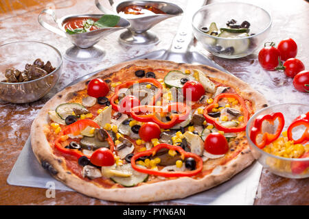details of delicious fresh vegetarian pizza on a wooden table Stock Photo