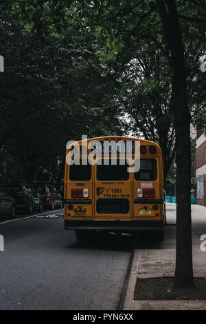 New York, USA - May 30, 2018: Yellow school bus parked on a side of the road in New York. The City of New York provides student with free transportati Stock Photo