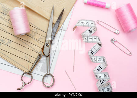 Shades of pink. Sewing pattern with scissors and tape measure used in fabric Stock Photo