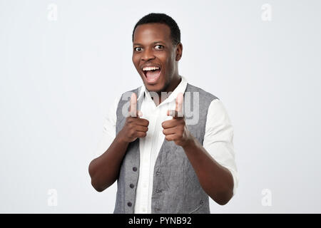 Young handsome african man with two hands guns sign gesture pointing at you camera Stock Photo
