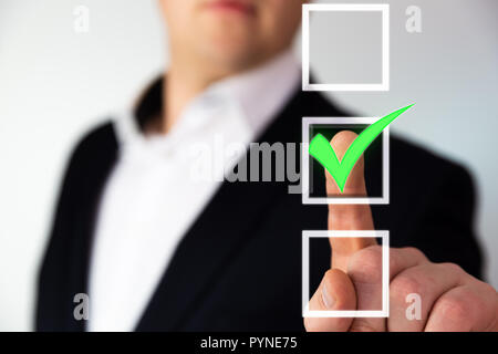 Businessman pushing checkbox button with a green tick. Stock Photo