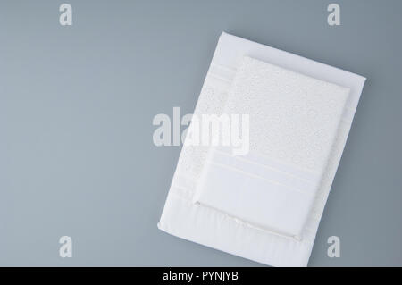 folded new tablecloth with embroidered patterns on a gray background, top view Stock Photo
