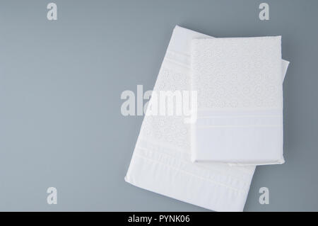 folded new tablecloth with embroidered patterns on a gray background, top view Stock Photo