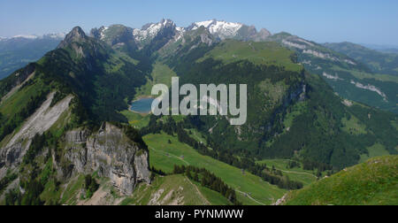 mountain landcape in the Swiss Alps with jagged peaks and a pristine blue mountain lake in the valley far below Stock Photo