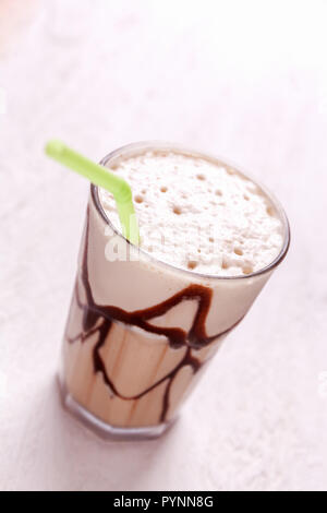 White Frappe Coffee Glass with iced drink on a light wooden table. color correction filter Stock Photo