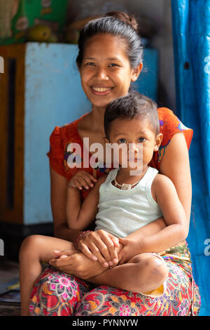 NUSA PENIDA, INDONESIA, JANUARY 12, 2018 : A young mom is posing with her son at home in a small village of Nusa Penida island near Bali, Indonesia Stock Photo