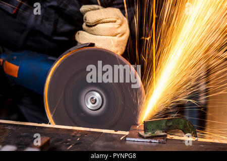 portrait of manual worker with grinder in action Stock Photo