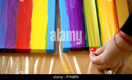 Female artist painting a rainbow with acrylic colors on canvas, hoe made art, DIY tutorial, colorful Stock Photo