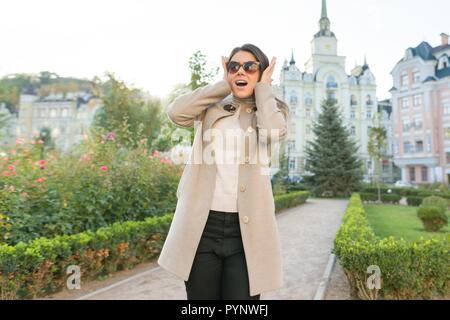 Outdoor portrait of a young woman covering her ears. Stock Photo