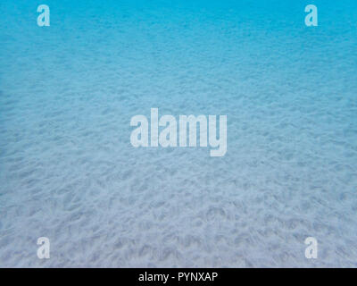 Ocean floor underwater with patterns and texture in sand in clear blue water Stock Photo