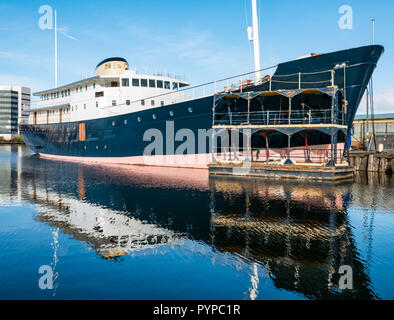 Leith docks, Edinburgh, Scotland, United Kingdom. 30th Oct, 2018. UK Weather: Sunshine on Leith this morning creates colourful reflections in the Water of Leith river. MV Fingal ship continues its refit and repainting in the dock from a former lighthouse tender to a luxury floating hotel due to open in January 2019 Stock Photo