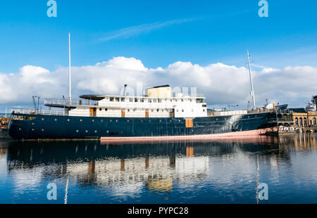 Leith docks, Edinburgh, Scotland, United Kingdom. 30th Oct, 2018. UK Weather: Sunshine on Leith this morning creates colourful reflections in the Water of Leith river. MV Fingal ship continues its refit and repainting in the dock from a former lighthouse tender to a luxury floating hotel due to open in January 2019 Stock Photo