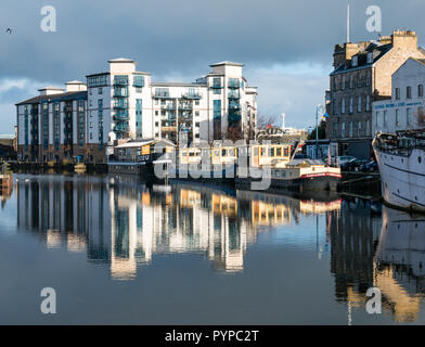 The Shore, Leith, Edinburgh, Scotland, United Kingdom. 30th Oct, 2018. UK Weather: Sunshine on Leith creates colourful reflections of the riverside buildings in the Water of Leith river. Queen's Quay, a modern development of apartments and moored river barges Stock Photo