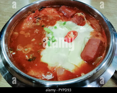 Delicious Korean food Yukgaejang spicy seafood soup with cheese, Yukgaejang Hot pot is Korean stew made with kimchi, noodles, cheese, ham, sausage, mu Stock Photo