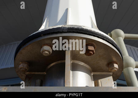 Rusty nuts and bolts fixing stainless steel mounting to wind turbine mast in cleveleys on the fylde coast in lancashire uk Stock Photo