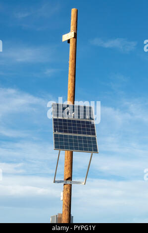 Solar panel on a pole used to power a security camera Stock Photo