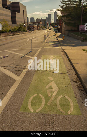 Green sign of a bicycle path drawn on the asphalt road. Lanes for cyclists. Cyclist on urban cycleway. Traffic signs and road safety. Stock Photo