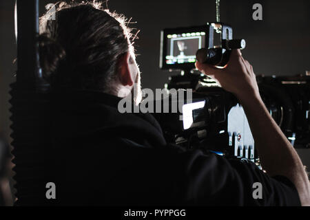 Professional videographer holding camera mounted on easy rig. Videographer using steadicam. Pro equipment helps to make high quality video without shaking. Stock Photo
