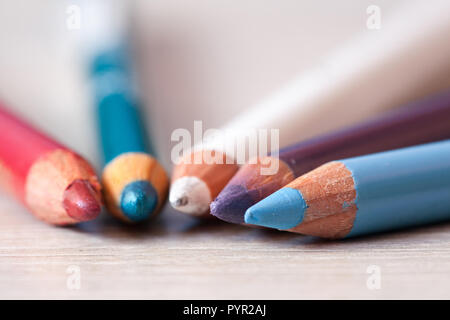 Group of cosmetic pencils. Pencils with unfocused petals. Makeup Pencils Stock Photo