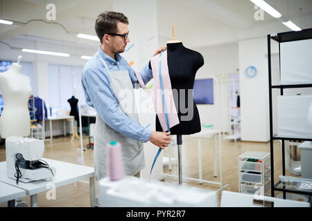 Tailor trying fabric on mannequin Stock Photo