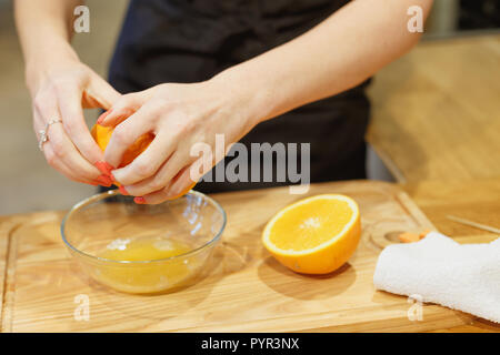close-up scene of squeezing oranges on kitchen selective focus hands Stock Photo