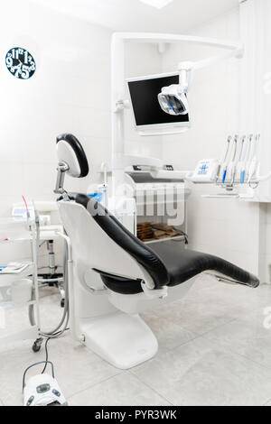 Vertical view of a dentist room with black seat. Modern dental practice. Dental chair and other accessories used by dentists Stock Photo