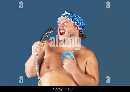 Funny fat man in blue cap sing in the shower. Fun and cleanliness Stock Photo