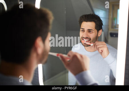 Cheerful man cleaning teeth Stock Photo