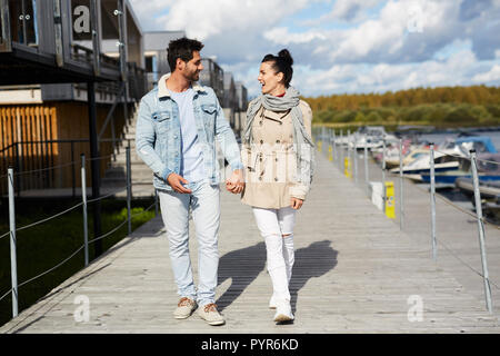 Excited young couple holding hands while walking together Stock Photo