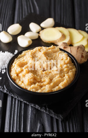 Authentic Recipe for Ginger Garlic Paste with Ingredients Closeup on a Black Wooden Table. vertical Stock Photo