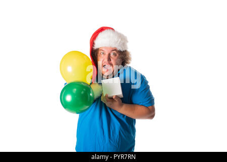 Funny fat man in Santa hat with balloons and gifts. Christmas and presents. Emotions Stock Photo