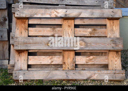 weathered wooden pallets in a row stored outdoors, row of wooden pallets Stock Photo