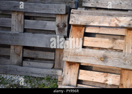 standing stacked wooden pallets, weathered wooden pallets in a row stored outdoors Stock Photo