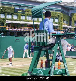 wimbledon tennis match umpire sitting in umpires chair above the players Stock Photo