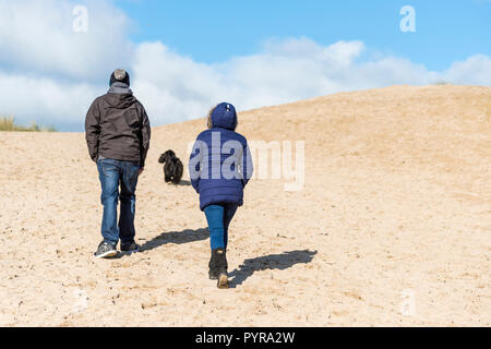 Dog walkers on a sand dune at Crantock Beach in Newquay in Cornwall. Stock Photo