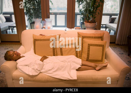 Mid-adult woman resting on a couch. Stock Photo