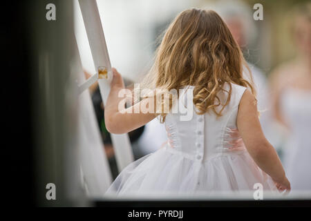 Young girl with long hair dressed as a flowergirl. Stock Photo