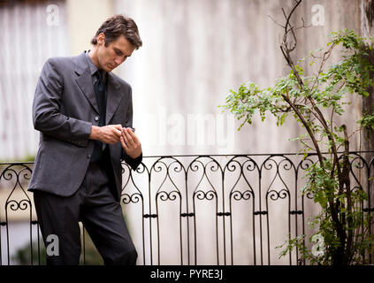 Side view of a man busy with his phone. Stock Photo