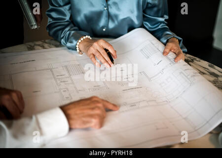 People working on architectural blueprint. Stock Photo