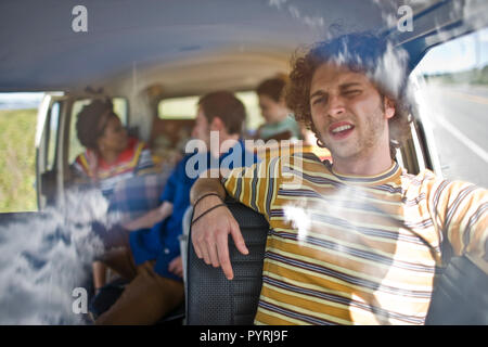 Young people sitting inside a van. Stock Photo