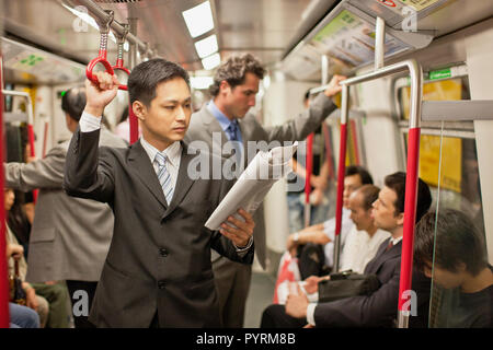 Businessman reading a newspaper while on a train. Stock Photo