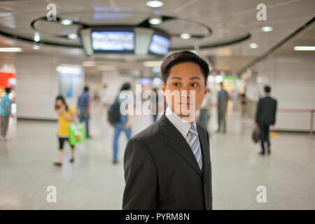 Young businessman standing in a busy train station. Stock Photo