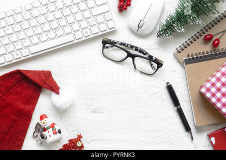 Merry Christmas Festival.  Flat lay Office desk table with computer wireless mouse and keyboard and Christmas decoration toys and ornaments on rustic  Stock Photo