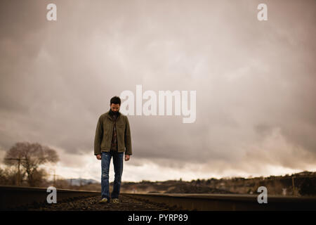 Man standing alone on train tracks. Stock Photo