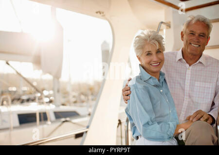 Smiling senior couple hold hands on the deck of a boat. Stock Photo