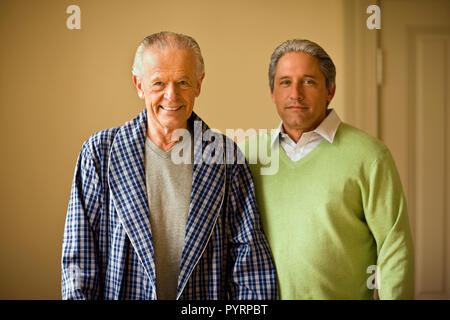Senior man in his bathrobe and his mature son pose for a portrait. Stock Photo