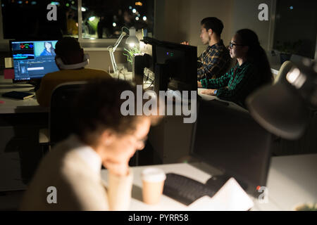 People Working in Office at Night Stock Photo